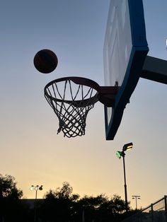 a basketball going through the hoop at sunset