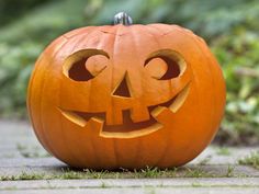 a carved pumpkin sitting on top of a sidewalk