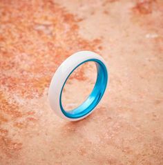 a blue and white ring sitting on the ground