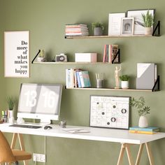 a desk with a computer on top of it and some shelves above the desk in front of it