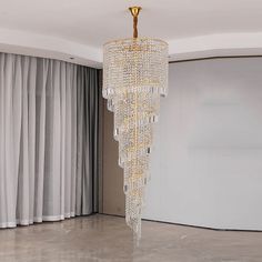 a large chandelier hanging from the ceiling in a room with curtains and drapes