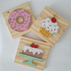 three wooden coasters with different designs on them, one has a frosted donut and the other has sprinkles