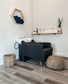 a chair and ottoman in a room with wood flooring next to a shelf filled with bottles