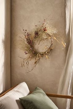 a wreath hanging on the wall above a bed