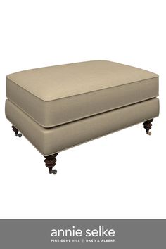 an upholstered footstool with wheels and casteors on the bottom is shown