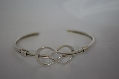 This is our beautiful delicate infinity design. Hand crafted of solid sterling silver we polish this off to give it a real shine. Adjustable but small should fit up to about 7 inch wrist and adjust down as small as needed. Adjustable Infinity Bracelet For Formal Occasions, Classic Adjustable Infinity Jewelry, Adjustable Infinity Jewelry With A Modern Twist, Adjustable Elegant Nickel-free Cuff Bracelet, Elegant Silver Hypoallergenic Cuff Bracelet, Elegant Adjustable Sterling Silver Cuff Bracelet, Modern Twist Adjustable Bangle As A Gift, Adjustable Silver Bracelets With A Modern Twist, Adjustable Bangle With A Modern Twist As A Gift