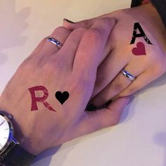 two people holding hands with matching tattoos on their fingers and wrist, one has a watch