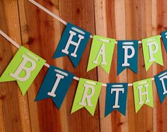 a happy birthday banner hanging on a wooden fence