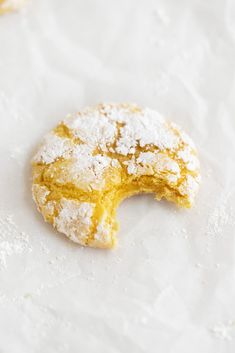 a powdered sugar doughnut on a piece of parchment paper