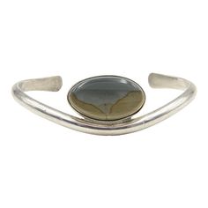 Vintage Native American sterling silver cuff bracelet featuring an oval agate. Marked on the back sterling.  Interior of the cuff measures 4.5" with an additional 1.25" gap for a total circumference of 5.75".  Sterling Silver is relatively malleable, thus this cuff is slightly adjustable. Width measures 2.34" straight across the widest part (from wrist bone to wrist bone). Bracelet face measures .72" tall (the face of the bracelet, north to south). Bracelet depth from top to the underside of wri Adjustable Oval Modern Cuff Bracelet, Silver Oval Cuff Bracelet With Polished Finish, Oval Cuff Bracelet With Polished Finish As Gift, Adjustable Oval Bangle With Polished Finish, Formal Silver Oval Cuff Bracelet, Modern Adjustable Oval Bangle, Silver Oval Cuff Bracelet, Oval Cuff Bracelet With Polished Finish, Chanel Cuff Bracelet