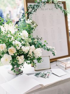 a table topped with white flowers and greenery