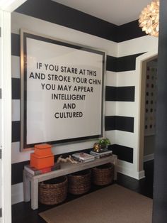 a room with black and white stripes on the walls, an orange basket is next to it