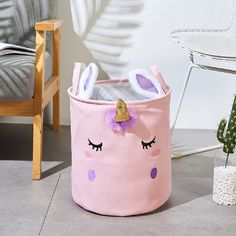 a pink toy bin with an unicorn face on it