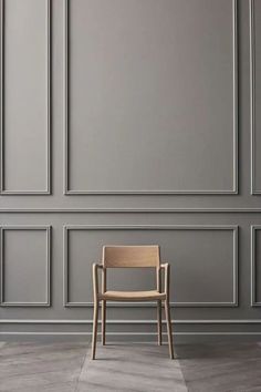 a chair sitting in front of a wall with gray paneling on the walls and floor