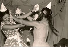 two women in dresses are throwing confetti on each other