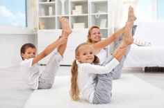 two girls and a boy are doing yoga on the floor