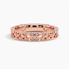 a rose gold ring with diamonds in the center and an intricate design on it's side