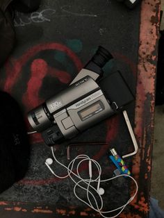 an electronic device is laying on the ground next to some wires and earbuds