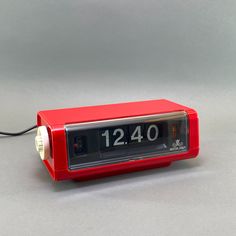 a red alarm clock sitting on top of a table