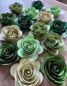 paper flowers are arranged on a table for decoration or wall hangings in green and beige colors