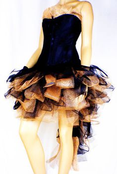 a mannequin wearing a black and gold dress with ruffles on it