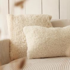 two white pillows sitting on top of a couch