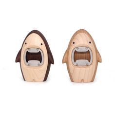 two wooden toys shaped like animals with faces and mouths, one is brown and the other is white