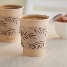 two coffee cups sitting next to each other on a table