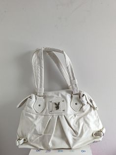 This is an authentic vintage Playboy bunny handbag. Great gift for any playboy fan. Dimension is approximately 16 inches in width. Genuine vintage item that exceeds 10-15 years of age and will have some signs of wear and tear including but not limited to tears, holes, stains, loose and pulled threads, dust, lint, discoloration, etc. These are no longer made or sold and stores and the condition is second hand vintage. Color not 100% white o Vintage Bag Aesthetic, Bunny Bags, Fasion Outfits, White Handbag, Playboy Bunny, Vintage Purses, Vintage Color, Pretty Bags, Vintage Handbags