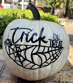 a white pumpkin with the words trick or treat painted on it's front and side