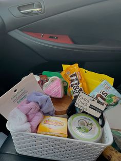 a car filled with lots of different types of food and snacks in a basket next to a steering wheel