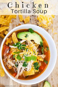 chicken tortilla soup in a white bowl with avocado and cilantro