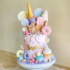 a pink birthday cake decorated with sweets and candies