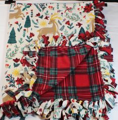 three pieces of red and green plaid fabric with deers on them, one in the middle