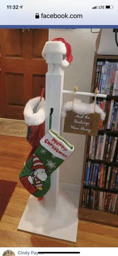 a christmas stocking holder with stockings and santa hats hanging from it's pole