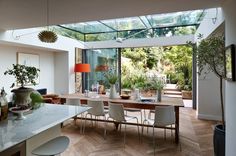 a dining room table and chairs with an open glass roof over it's outdoor area