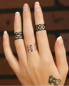 a woman's hand with two rings on it and one has a tattoo on her finger