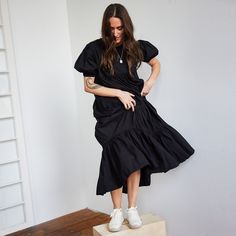 Thoughtfully crafted from ethically-sourced handwoven cotton and defined by its movement-enhancing tiered ruffles, this Short Sleeved Tiered Midi Dress is a timelessly elegant piece that will enliven your wardrobe. Effortless and flouncy, this ruffle dress falls midi length with arm coverage as well. Sizing: This collection emulates Japanese styling where fit is more generous and comfortable. Please specify size when ordering. S (US size 2-4) M (US size 6-8) L (US size 10-12) XL (US size 14-16) Elegant Tiered Cotton Midi Dress, Black Tiered Dress With Ruffles, Fitted Cotton Tiered Midi Dress, Fitted Tiered Cotton Midi Dress, Black Tiered Dress With Ruffle Hem, Fitted Tiered Cotton Ruffle Dress, Fitted Cotton Midi Dress With Tiered Skirt, Tiered Cotton Midi Dress With Ruffle Hem, Fitted Black Tiered Dress