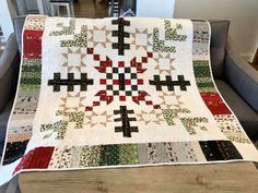 a quilted table topper on a couch in a living room with a chair