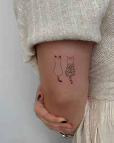 a woman with a small tattoo on her thigh shows off her tiny fox and cat tattoos