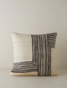 a black and white pillow sitting on top of a table