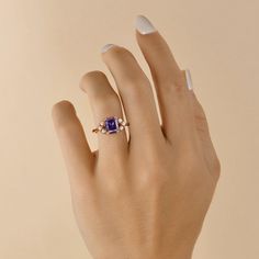 a woman's hand with a ring on it and a blue stone in the middle