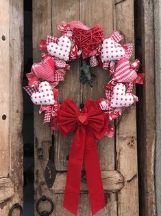 a red and white heart wreath hanging on a door