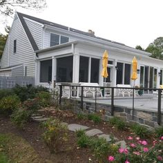 a house that has some yellow umbrellas on the front porch and side of it