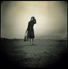 a woman standing in the middle of a field