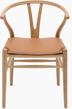 a wooden chair with tan leather upholstered on the seat and armrests