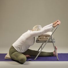 a woman is sitting on the floor doing yoga