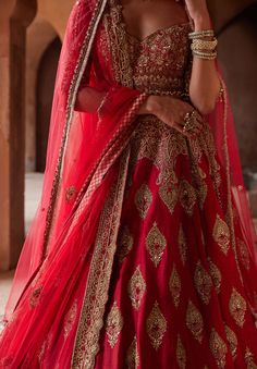 Editor's Note Unveil elegance in our cardinal red raw silk lehenga choli and belt ensemble. The scalloped net dupatta is adorned with an all-over booti pattern, intricately embroidered in gold ... Head Veil, Red Bridal Lehenga, Blouse Yoke, Silk Lehenga Choli, Raw Silk Lehenga, Bridal Dupatta, Bridal Lehenga Red, Red Lehenga, Lehenga Blouse