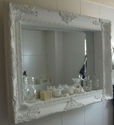 a bathroom mirror sitting on top of a white counter