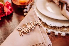 a place setting with personalized napkins and flowers